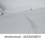 This image captures a stark and immersive view of a snow-covered mountain landscape in Pakistan, likely a high-altitude region.