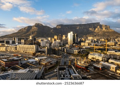 This image captures a stunning panoramic view of Cape Town's urban landscape with the iconic Table Mountain providing a majestic and picturesque backdrop on a clear day.