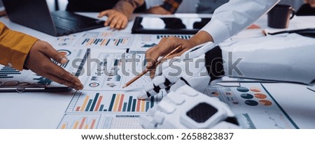 This image captures the synergy between humans and robots in an office environment, focusing on data analysis, teamwork, and modern business strategies.Noogenesis