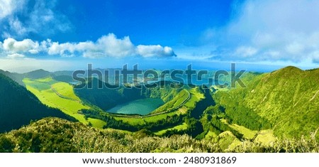 This image depicts a breathtaking panoramic view of the Sete Cidades on São Miguel Island in the Azores, Portugal. The landscape is characterized by its lush green volcanic crater lakes and mountains.