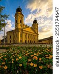 This image depicts the Protestant Great Church of Debrecen, a prominent landmark located in Debrecen, Hungary. The church’s striking yellow facade, adorned with neoclassical architectural elements