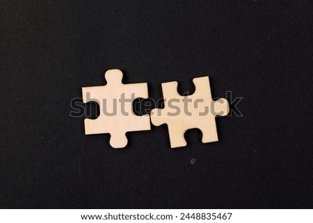 This image depicts two interlocking jigsaw puzzle pieces coming together seamlessly on a black background