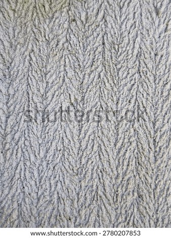This image displays a close-up of a surface featuring a herringbone pattern, a classic design characterized by its distinctive V-shape or 