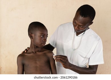 In This Image, A Doctor Is Disinfecting The Injection Site On A Black Boy's Arm After Malaria Vaccination In West Africa