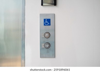 This image features an accessible elevator call panel with clear directional buttons for up and down, complete with the accessibility symbol.