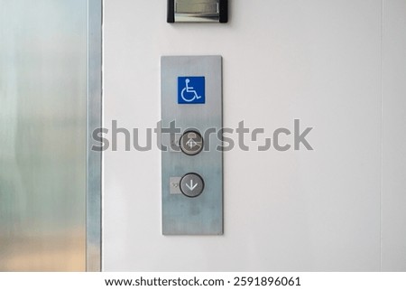 This image features an accessible elevator call panel with clear directional buttons for up and down, complete with the accessibility symbol.