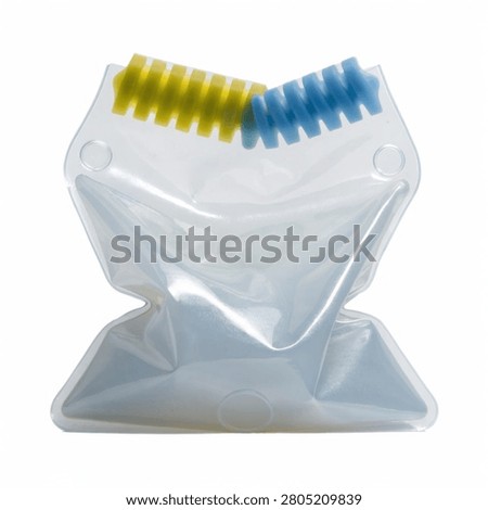 This image features a clear plastic pouch containing two coiled springs, one yellow and one blue, set against a plain white background. The pouch appears flexible and