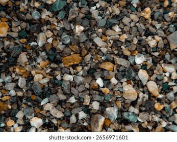 This image features a close-up of small, smooth pebbles and rocks scattered across a surface, varying in size