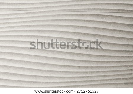 This image features a close-up of a textured surface with a repeating wave pattern, creating a sense of movement and depth