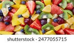 This image features a close-up of a vibrant fruit salad. The salad includes a variety of colorful fruits, such as kiwi, strawberries, and blueberries. This image is perfect for illustrating summer the