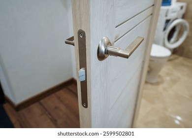 This image features a closeup view of a bathroom door, showcasing its intricate handle and details. The context suggests the presence of wood elements, adding to the overall ambiance of the room