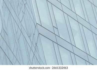 This image features a closeup view of a tall, imposing building that has an abundance of windows reflecting the surroundings perfectly