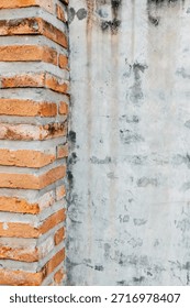 This image features a close-up view of a brick corner against a weathered concrete wall, showcasing unique textures and colors that highlight industrial design.