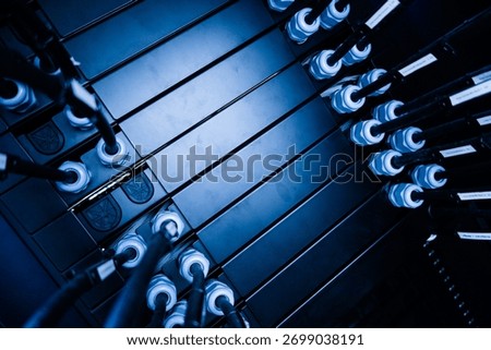 This image features a close-up view of a black battery rack with power connectors, showcasing the arrangement and technology involved in energy storage systems.