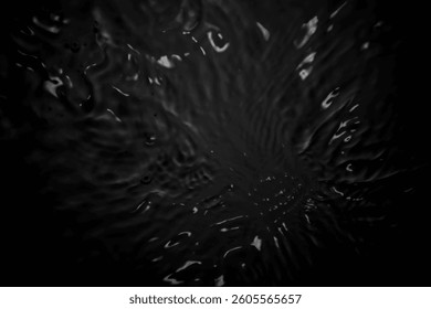 This image features a dark abstract water texture showcasing intricate ripples and reflections. Perfect for backgrounds, designs, or artistic projects.