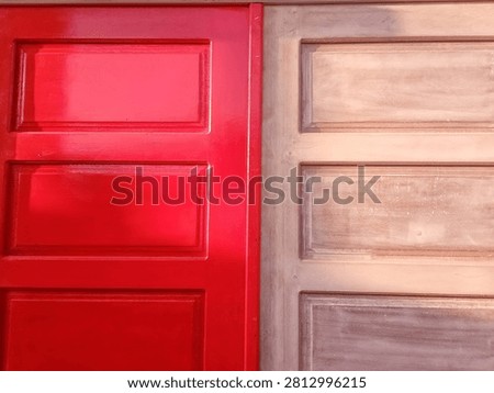 This image features a front-facing, close-up view comparing a painted wooden door surface with an unpainted, raw wooden door surface placed side-by-side.
​The left side of the frame showcases a traditional paneled wood design coated in a vibrant, glossy cherry red paint. The glossy finish reflects ambient light, highlighting the raised rectangular panel structures and clean recessed borders. The right side shows a matching wooden paneled door design in its unfinished state, featuring a natural light brown wood grain surface with visible brush strokes, sanding marks, or a light base coat of primer. This comparison highlights the visual transformation of a wooden door before and after the painting process during a home renovation or woodworking project.