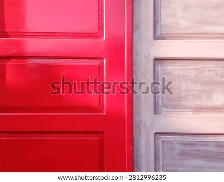 This image features a front-facing, close-up view comparing a painted wooden door surface with an unpainted, raw wooden door surface placed side-by-side.
​The left side of the frame showcases a traditional paneled wood design coated in a vibrant, glossy cherry red paint. The glossy finish reflects ambient light, highlighting the raised rectangular panel structures and clean recessed borders. The right side shows a matching wooden paneled door design in its unfinished state, featuring a natural light brown wood grain surface with visible brush strokes, sanding marks, or a light base coat of primer. This comparison highlights the visual transformation of a wooden door before and after the painting process during a home renovation or woodworking project.