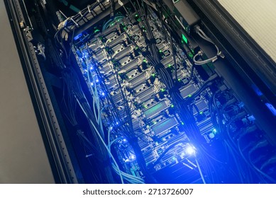 This image features a modern server rack showcasing advanced technology with neon blue lighting. The intricate wiring and hardware illustrate the core of data storage and processing systems.