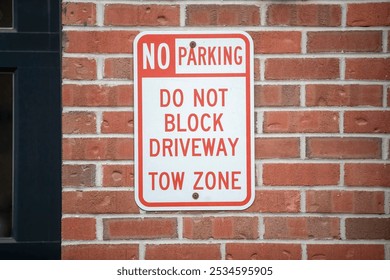 This image features a "No Parking" sign mounted on a brick wall, clearly conveying important parking regulations. - Powered by Shutterstock