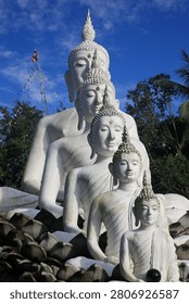 This image features a row of five white Buddha statues of descending sizes, a prominent landmark at Wat Nong Chik in the Khao Kram Subdistrict of Krabi, Thailand.