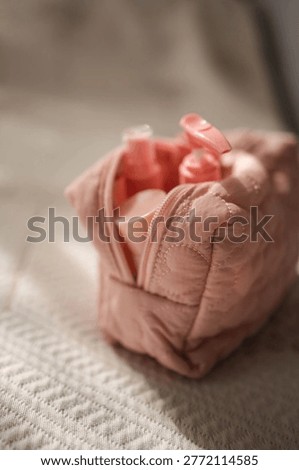 This image features a soft pink puffy cosmetic bag with charming heart shaped quilted details