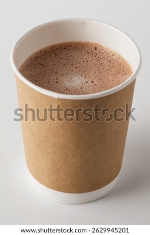This image features a steaming cup of hot cocoa in a disposable paper cup with a brown sleeve, set against a clean white background, perfect for cold days.