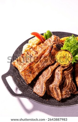 This image features a substantial platter of grilled meats, including ribs and sausages, along with grilled corn, bell peppers, lettuce, and a lemon, presented on a dark griddle.