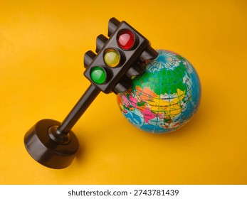 This image features a toy traffic light alongside a small globe.