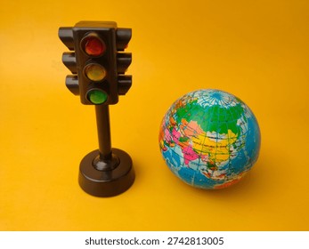 This image features a toy traffic light alongside a small globe.