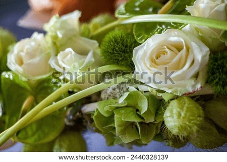 This image features an up-close view of a floral arrangement with pristine white roses and an assortment of lush greenery. The varied textures and vibrant greens create a refreshing and natural