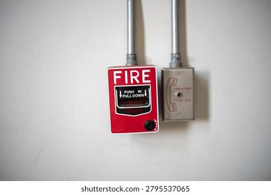 This image features a wall-mounted fire alarm and pull station in a building, used for emergency alerts and fire safety measures to ensure protection and prompt response.