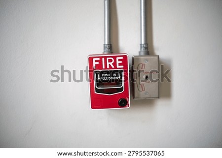 This image features a wall-mounted fire alarm and pull station in a building, used for emergency alerts and fire safety measures to ensure protection and prompt response.