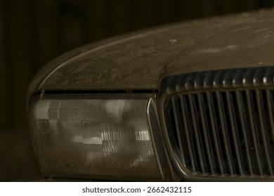 This is an image featuring a closeup view of a dirty car hood, along with the accompanying headlight, showcasing typical signs of weathering and use
