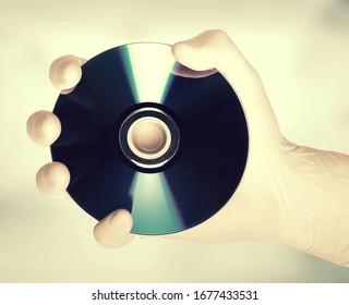This is an image of a hand holding a cd, metaphor for data protection                             