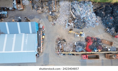 This image offers a detailed overhead look at the complex operations of a waste management facility. The scene is a mixture of order and disorder, with piles of recyclable materials segregated into