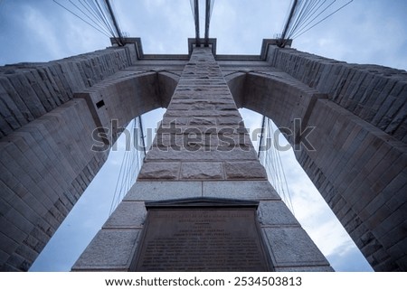This image offers a dramatic upward view of the Brooklyn Bridge's iconic stone towers and suspension cables. 