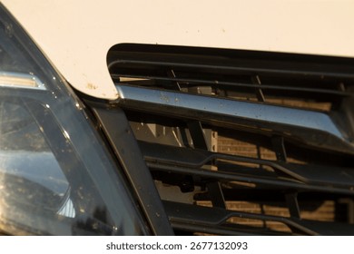This image presents a closeup view of a cars front grille and headlight, emphasizing the intricate design and unique structure of various essential automotive elements and features