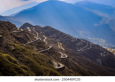 This image showcases a breathtaking view of winding mountain roads snaking through a dramatic landscape. - Powered by Shutterstock