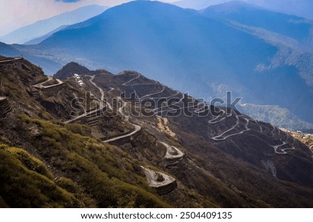 This image showcases a breathtaking view of winding mountain roads snaking through a dramatic landscape.
