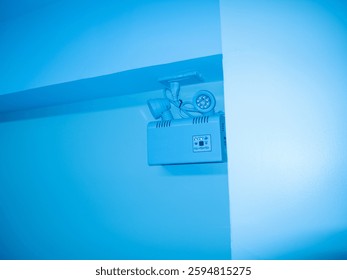 This image showcases a ceiling-mounted projector emitting a calming blue light in a modern room setting, enhancing the ambiance and aesthetics.