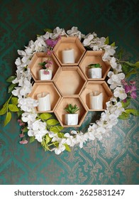 This image showcases a charming hexagonal wooden shelf unit mounted on a teal wallpaper with a subtle damask pattern. The shelf is arranged in a honeycomb style.