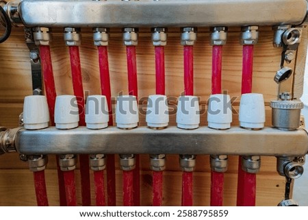 This image showcases a closeup view of a complex heating system that features striking red pipes along with whitecolored caps, illustrating the intricate design and functionality of the machinery