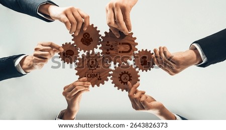 This image showcases a collaborative effort in a business environment where teamwork and gears symbolize customer relationship management strategies and concepts. Amity