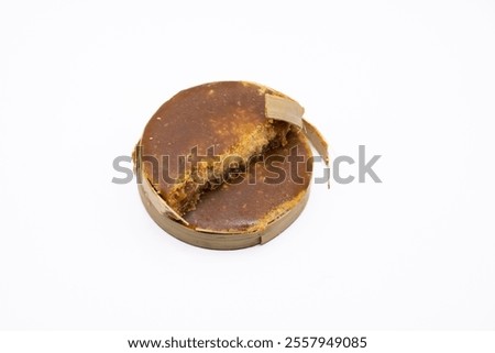 This image showcases a disc of Gula Melaka, a traditional Southeast Asian palm sugar, with a distinctive golden brown hue and a natural, textured surface. 