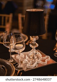 This image showcases an elegantly arranged table featuring a crystal lamp centerpiece, exquisite glassware, and decorative beads creating a sophisticated atmosphere.