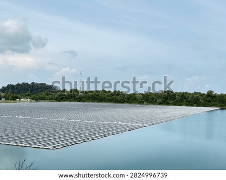 This image showcases a floating solar photovoltaic (FPV) system, where a large array of solar panels is installed on the surface of a water reservoir. The panels are mounted on buoyant floating structures that keep them securely positioned on the water while allowing them to generate clean, renewable electricity.