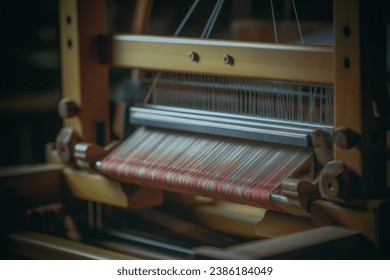 This image showcases the intricate details of an artisan hand loom in the process of weaving a textile - Powered by Shutterstock