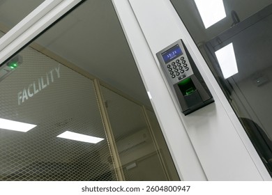 This image showcases a state-of-the-art access control system at a facility entrance, featuring a keypad and biometric fingerprint scanner for enhanced security.