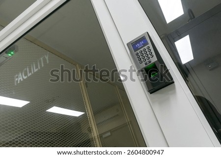This image showcases a state-of-the-art access control system at a facility entrance, featuring a keypad and biometric fingerprint scanner for enhanced security.