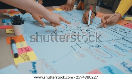 This image showcases a vibrant teamwork environment where diverse hands engage in a brainstorming session, utilizing sticky notes and markers on a whiteboard for strategic planning. SACTR